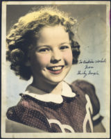 Early photograph of Shirley Temple as a child. She is smiling, has short, curly hair, and is wearing a dress with a white collar. Written on the photograph is "To Andy Warhola from Shirley Temple."