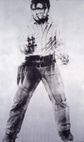 Screenprint of Elvis Presley in black paint on a silver canvas. He is looking towards the camera while