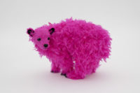 A foam bear sculpture covered in pink feathers.