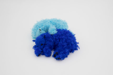 Two foam bear sculptures appear to be cuddling. One is covered in navy blue feathers and the other in baby blue feathers.