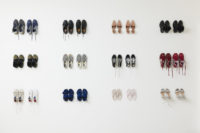 Photograph of thirty-two pairs of shoes on a white background. There are two pairs of the same shoes, one new and one used, paired together. The two pairs are photographed four rows across and three rows down.