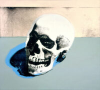 A screenprint of a white skull facing to the left on a gray surface with an off white background.