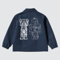 Navy blue jacket with white embroidered designs of a cartoon-like figure by the artist KAWS and a vintage robot by Andy Warhol on the back.