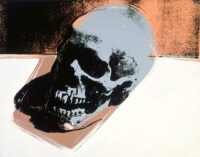 A skull screenprint painting by Andy Warhol featuring a black skull rotated on its side against a split background of brown and white.
