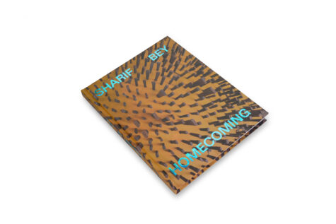 Cover of a book titled "Sharif Bey: Homecoming," featuring a dynamic pattern of scattered, raised rectangular shapes on a brown background.